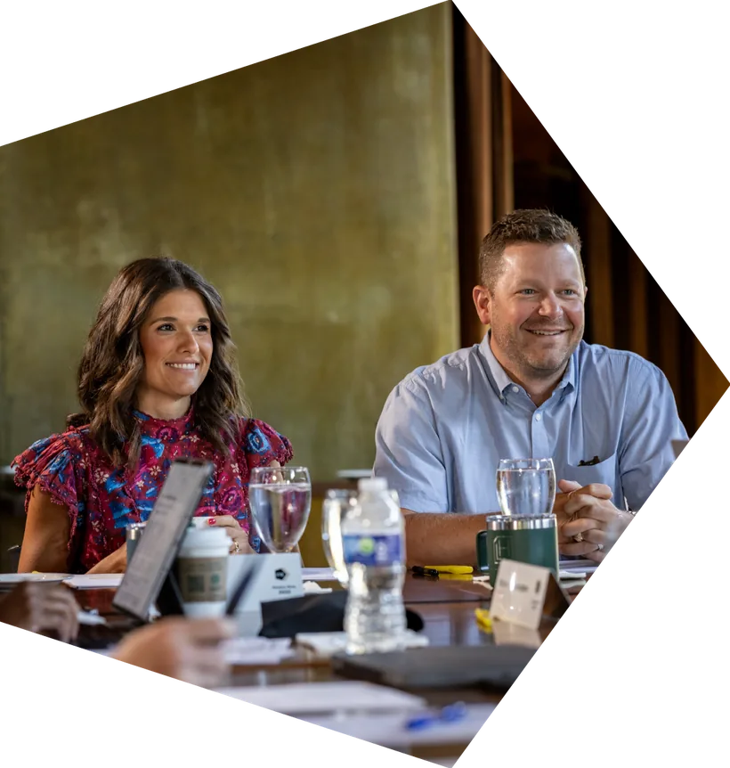 C12 members smiling together around the table at a monthly peer forum