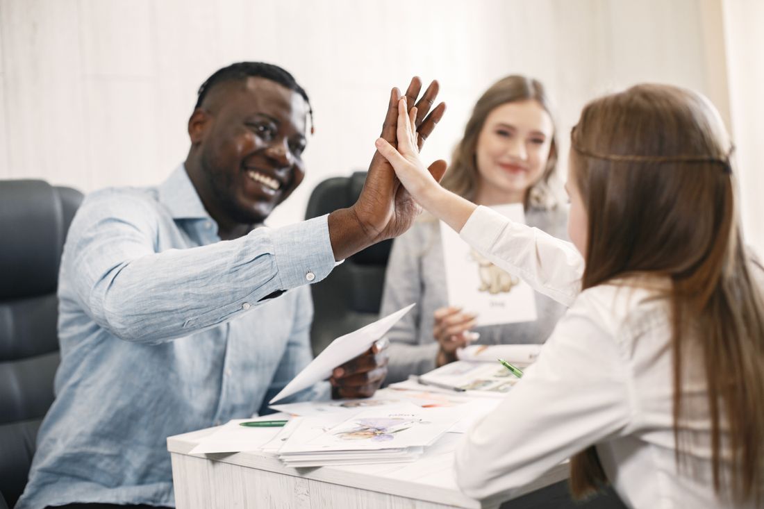 A child sharing a high five with a tutor after finishing their work