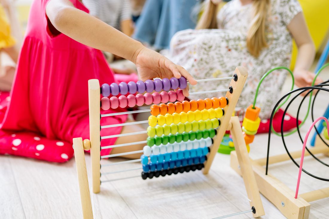 A young child using a colorful abacus to learn counting