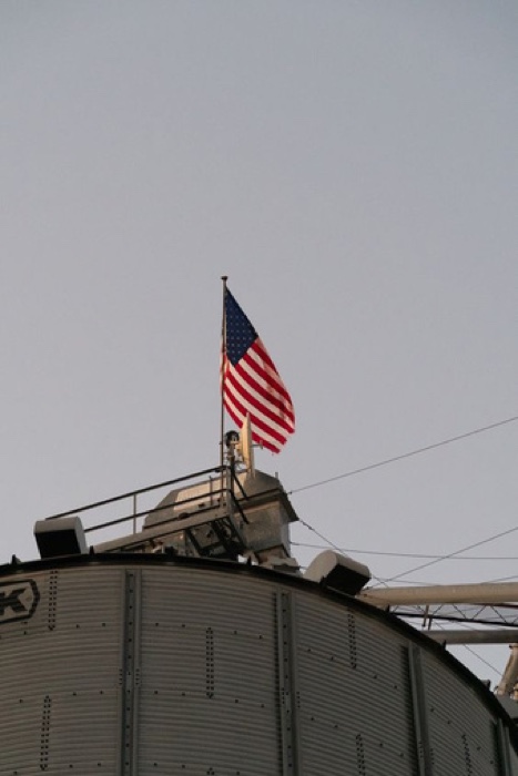 An American flag flying atop a grain bin
