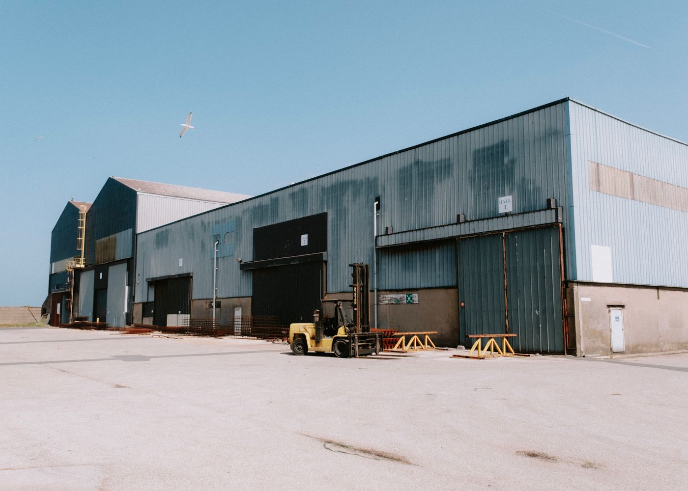 Forklift and steel racks outside an Imperial Fence Supply yard