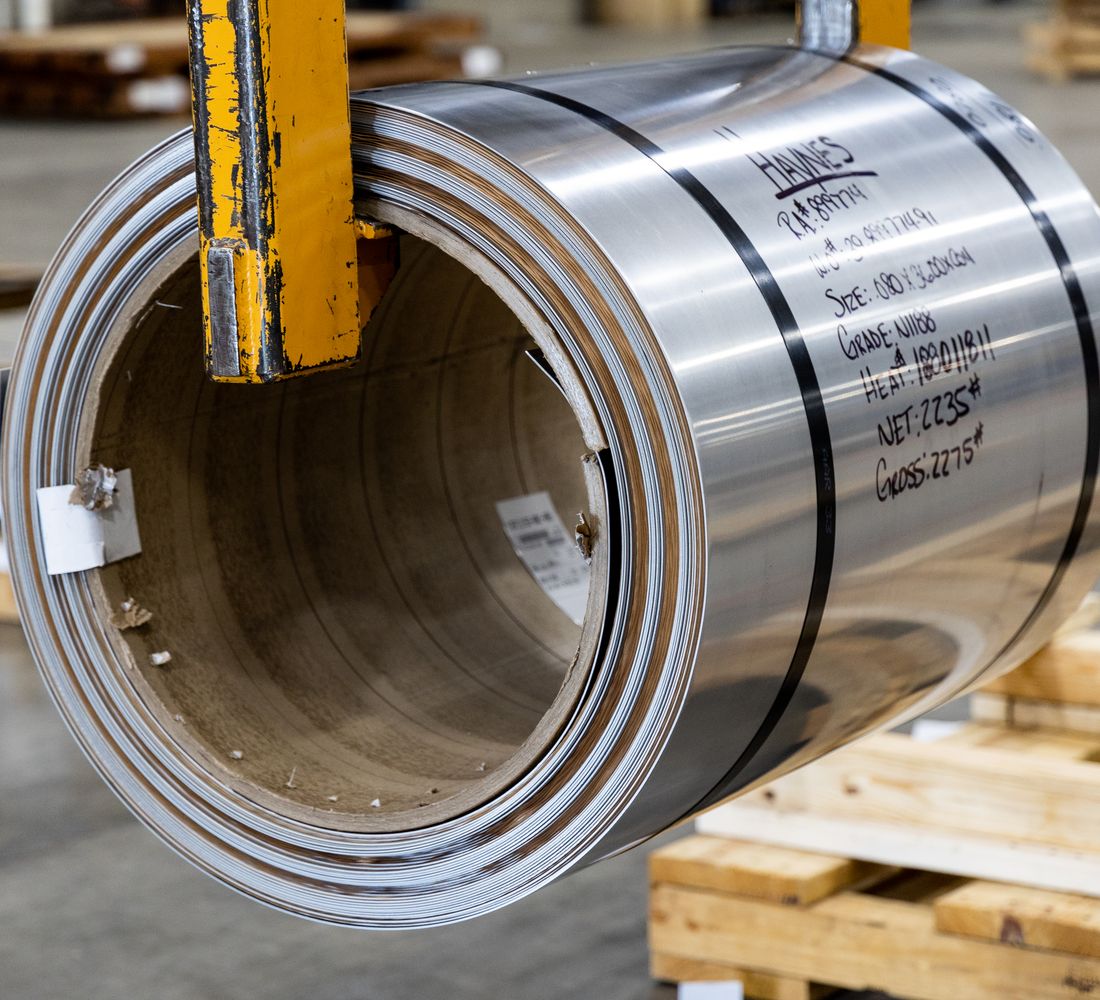 Coil of steel stock with spec markings on the warehouse floor