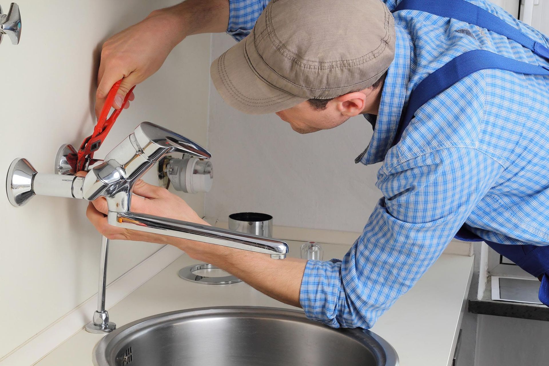 A chrome faucet and fixtures on a kitchen counter beside a sink