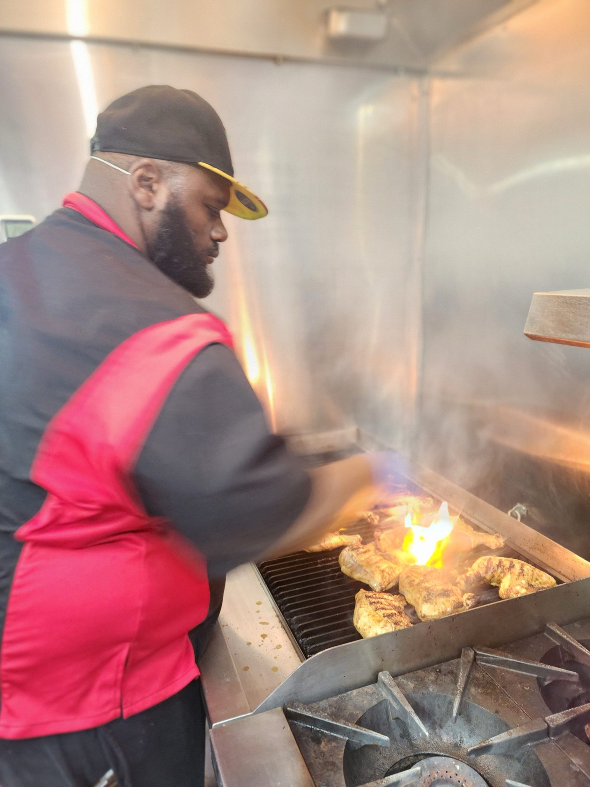 Chef Benny grilling chicken over the flame