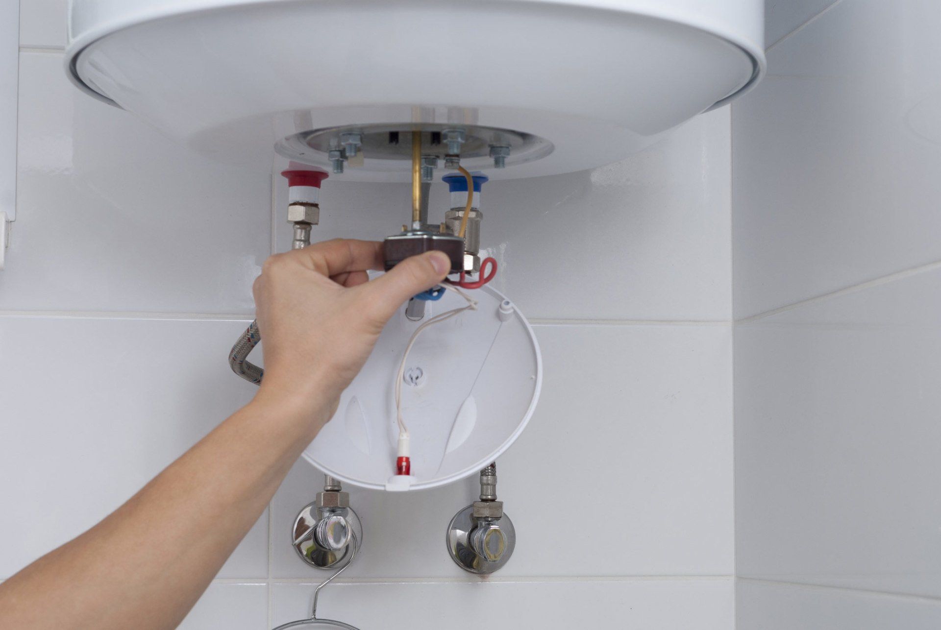 Plumber servicing the connections on a water heater for replacement