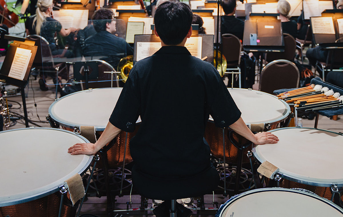A timpanist performing with the Louisville Orchestra outdoors